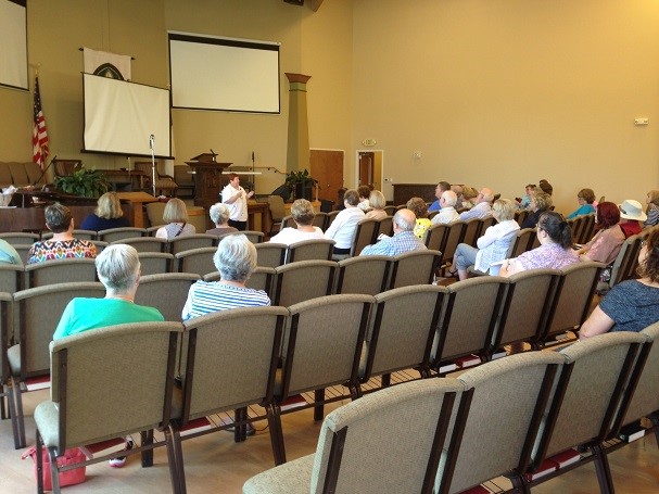 Lady addressing a goup of people about grave dousing.